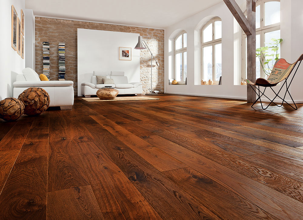 Rénovation de parquet massif - SF Bois et PVC Parquet massif chêne teinté foncé rénové dans un loft avec mur en pierre